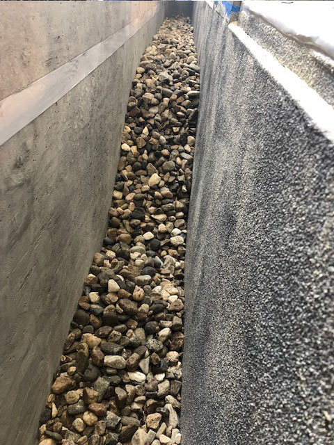 Gravel installed between window foundation and light well foundation