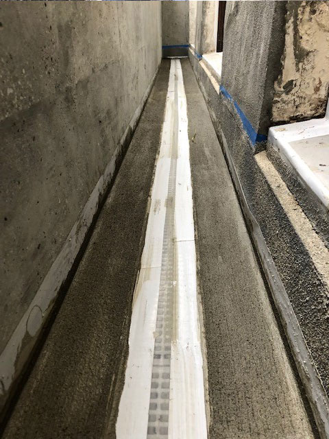 High performance fast set cement applied to both sides of channel drain