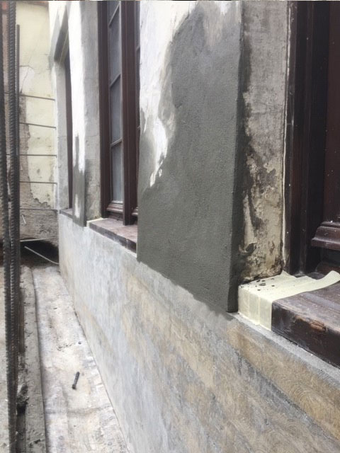 Veneer smooth stucco applied over foundation