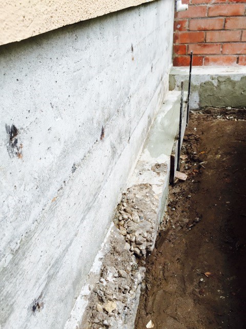 Foundation footing crack repairs prior to waterproofing