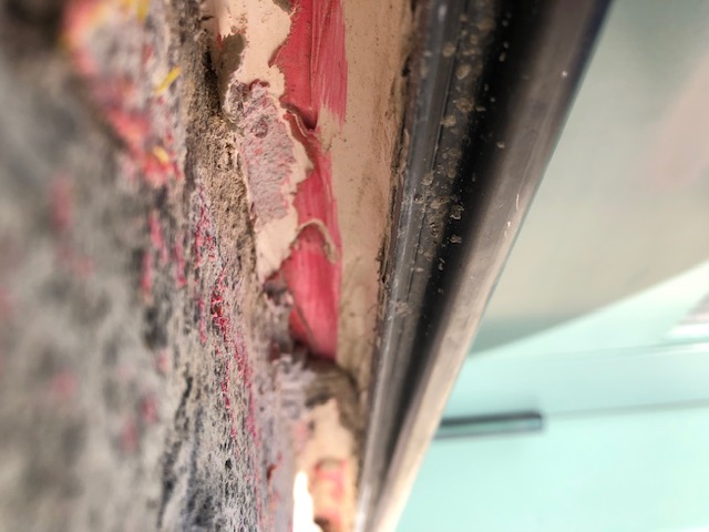 Visible gaps under door threshold sealant creating interior water damage