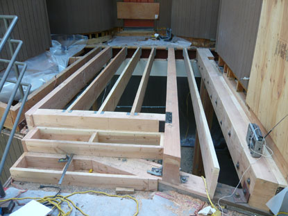 Elevated courtyard deck joist installation connected to step transition