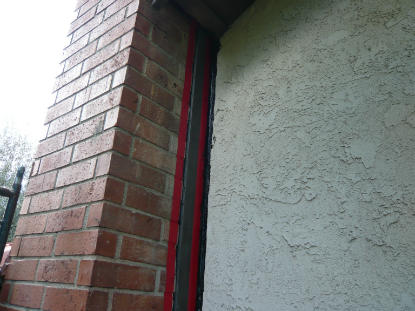 Installed chimney, stucco wall transition counter flashing controlling moisture